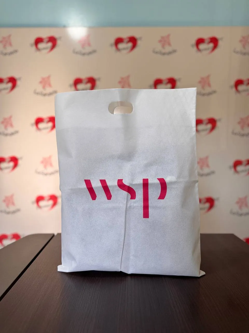 Bolsa blanca de friselina con manija troquelada y logo impreso en rojo