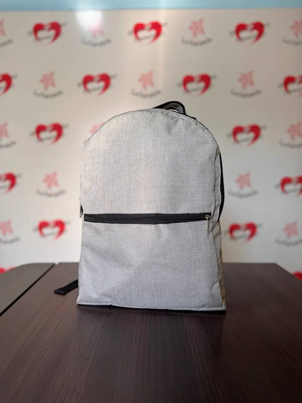 Mochila gris melange con cierre frontal horizontal y tiras negras
