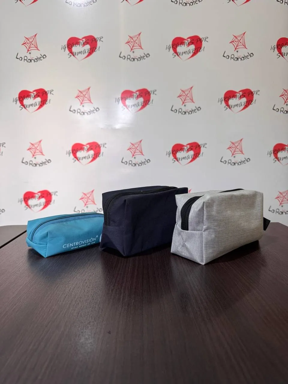 Tres neceseres rectangulares con cierre, en celeste, azul marino y gris melange